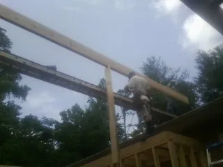 Carpenter setting a ridge beam over a new addition frame — Ice Dam Removal by Roofing Brothers in Big Pool