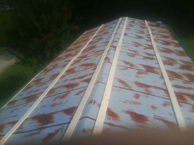 Rusted metal roof panels with new wood purlins before replacement — Storm Damage Roof Repair in Big Pool by Roofing Brothers