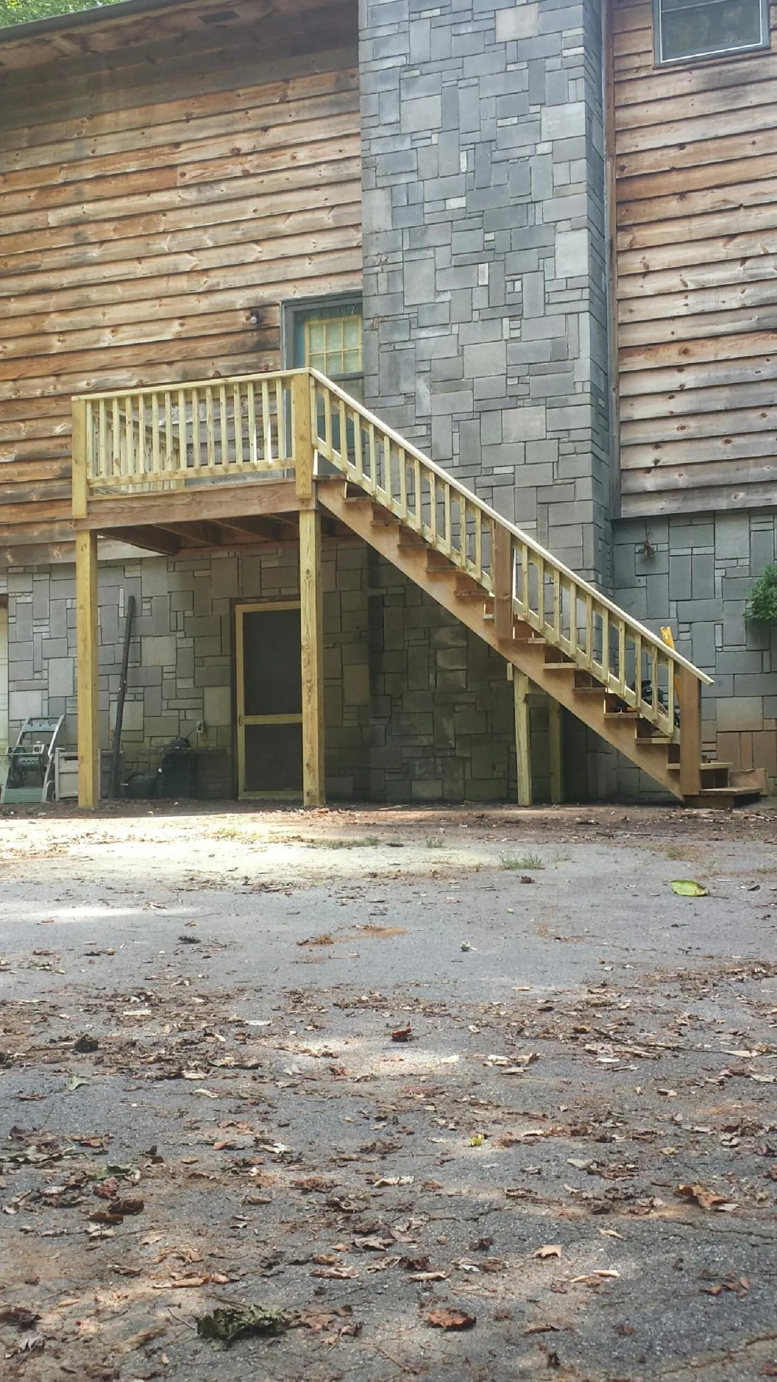New pressure treated deck and stair landing on a log home in Big Pool